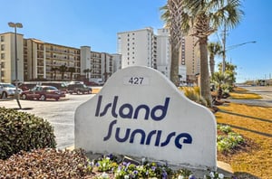View from the street of Island Sunrise with the propertys entry sign out front