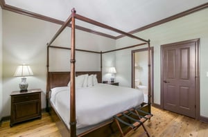 The master bedroom with a fourposter bed at Water Street Hotel  Marina in Apalachicola Florida