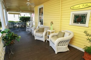 A spacious outdoor porch with cozy chairs at Coombs Inn  Suites in Apalachicola Florida