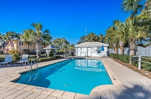 The fencedin swimming pool has a cabana with restrooms.