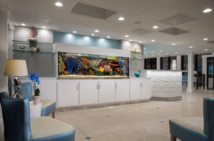 The lobby at Bilmar Beach Resort with a large fishtank next to the reception desk