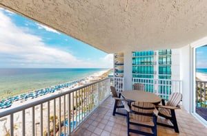 A private balcony with chairs and tables at Romar Tower in Orange Beach Alabama
