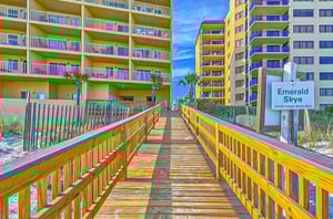 A wooden boardwalk leading towards Emerald Skye in Orange Beach Alabama