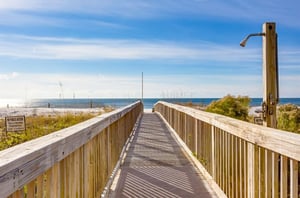The boardwalk and outdoor shower and Mediterranean Condominiums