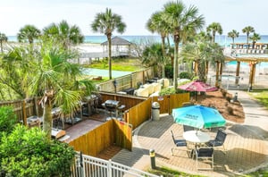 A poolside patio with grills and seating for outdoor cooking and dining