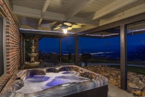 Hot tub on the patio with city lights in the background at Best View Ever A 5 bedroom cabin rental located in Pigeon Forge