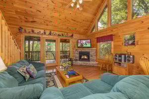 Living room with sofa, loveseat, fireplace, and TV at Cubs Crossing, a 3 bedroom cabin rental located in Gatlinburg