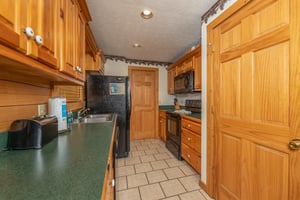 Galley kitchen with black appliances at Cubs Crossing, a 3 bedroom cabin rental located in Gatlinburg