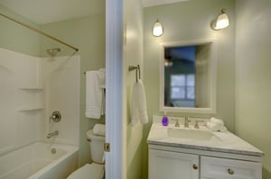 The private en suite bath features a showertub combo, wide vanity, and soft lighting—just steps from the king bedroom for added comfort and convenience.