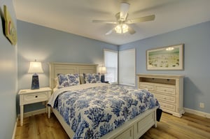 This guest bedroom at 406 Harbour Oaks offers a cozy queen bed, coastal colors, and plenty of natural light—ideal for couples or solo travelers enjoying St. Simons Island.
