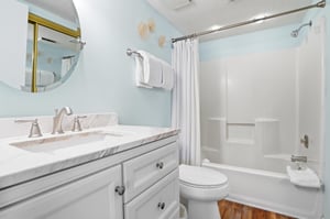 Marblestyle vanity and updated fixtures complement a clean, welldesigned space off the primary bedroom.