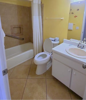 The guest bathroom features a tiled tub and shower combination with a clean, functional layout and easy access from the main living area.