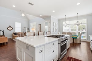 Statement range with a custom hood and open sightlines back to the dining area — no shortcuts in this kitchen.