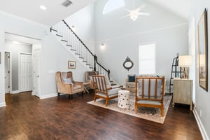 Soaring ceilings, an open ironrail staircase, and the first glimpse of the homes expansive main level.
