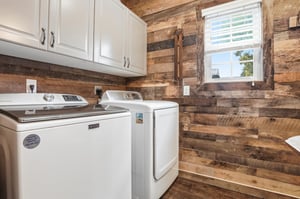 Fullsize washer and dryer behind that same reclaimed wood wall — everything you need for a longer stay.