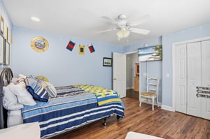 Wider view with closet doors and anchor art — every corner of this room stayed on brief.