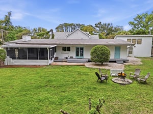 Backyard view of 530 Delegal showing the fire pit, seating, and open lawn area.