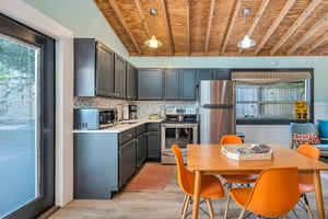 Guest house kitchen and dining area at 530 Delegal featuring a full kitchen, dining table, and direct access to the pool courtyard on St. Simons Island.