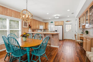 Open kitchen with natural wood cabinetry, wraparound counters, breakfast bar, and an easy connection to the dining area.