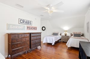 Wide view of the upstairs kingandtwotwin bedroom showing bed placement and dresser storage.