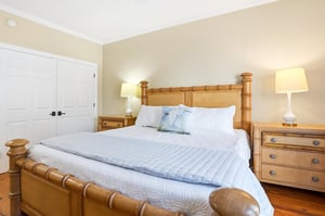 Alternate angle of the main floor king primary suite showing bedside storage and the room layout.