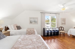 Fullroom view of the upstairs kingandtwotwin bedroom with the king bed on one side and twin beds on the other.
