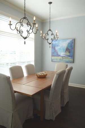 Slipcovered chairs, plantation shutters, and a full table make dinner at home feel worth doing.