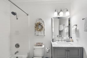 Bathroom with tubshower combination, marblestyle vanity, and bright lighting.