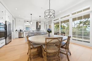 The open dining area seats the group between the kitchen island and wide doors to the porch.