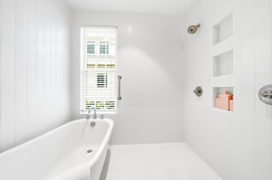 The main suite bath offers both a soaking tub and a spacious tiled shower.