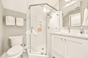 This bright bath serves the upperlevel bedrooms with a tiled shower and practical vanity storage.