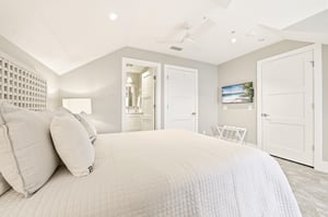 A wallmounted TV, nearby full bath and balcony access round out this upstairs bedroom.