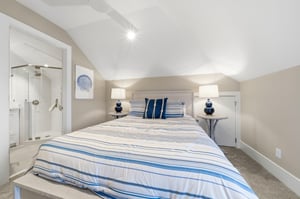 The upperlevel queen room sits directly beside a glassshower bath for an easy morning routine.