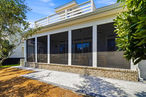 The rear exterior shows how the porch spans the open living area beneath the oceanfacing balcony.