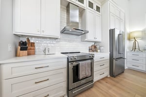 A smooth cooktop, vent hood and adjacent counters anchor the cooking area.