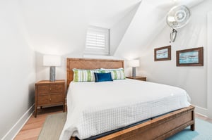 A woven headboard and greenandblue accents warm the wooden furnishings.