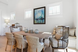 Woven chairs and a builtin bench provide seating beside the living area.