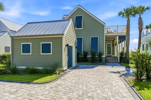 The paver driveway leads to the covered front entrance.