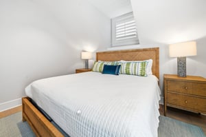 Matching bedside chests frame the bed beneath the sloped ceiling.