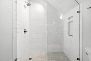 A recessed niche provides shelf space beneath the sloped ceiling.