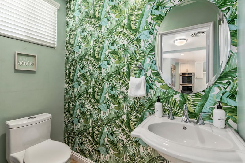 Guest bathroom adorned in lovely green wallpaper