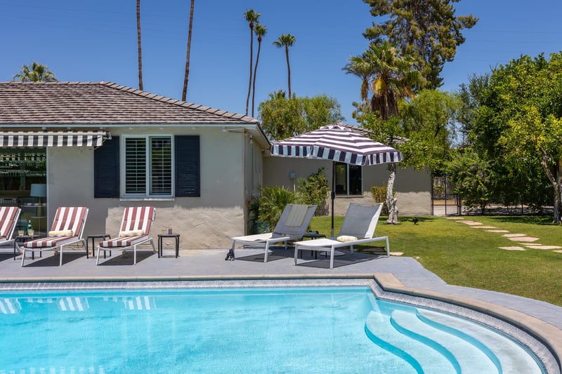 Striped umbrellas create shade by the pool