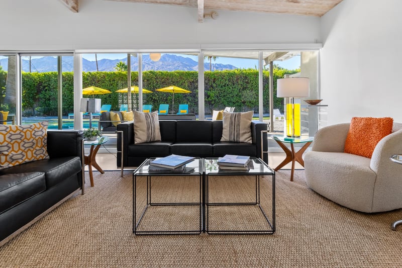 Relax in your stylish living room with soaring exposed beams and floortoceiling windows framing mountain views and pool deck.