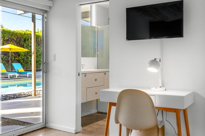 Your bright workspace overlooks the sparkling pool, perfect for catching up on emails before diving in for a refreshing swim.