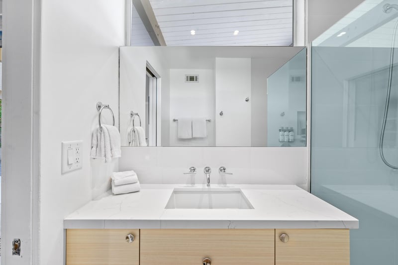 Unwind in your pristine ensuite with sleek marble counters, fresh linens, and a spacious glass shower waiting to refresh you.