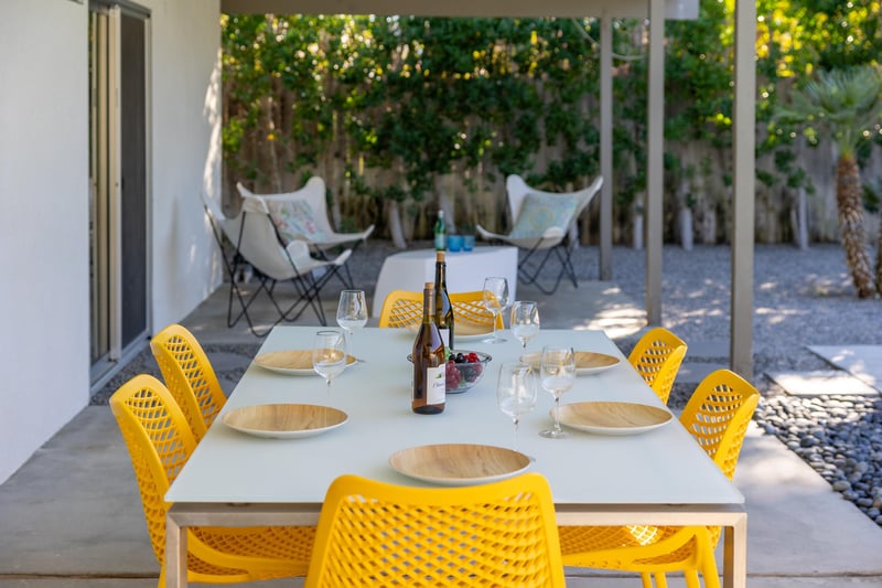 Enjoy al fresco dining on your covered terrace, where bright yellow chairs invite memorable meals under dappled shade.