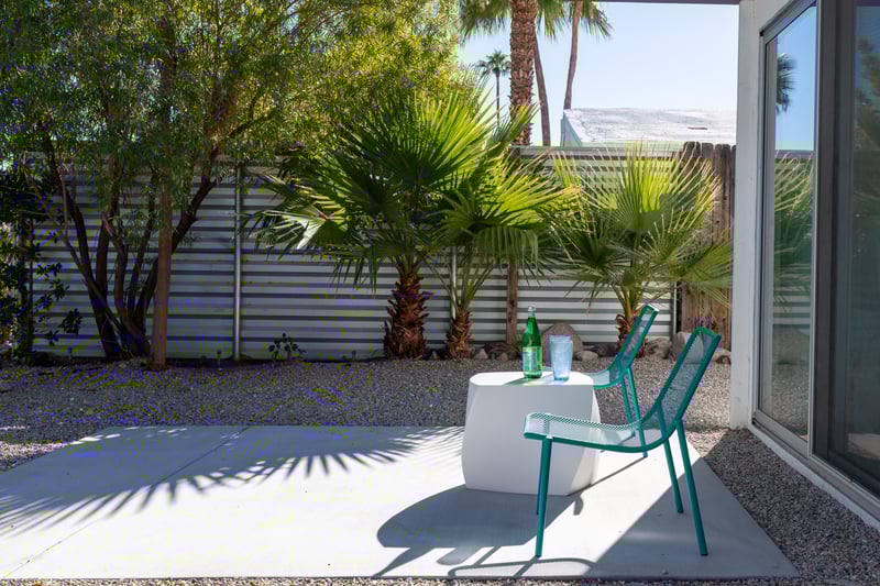 Step onto your private patio where tropical palms create perfect shade for afternoon relaxation with refreshing drinks.