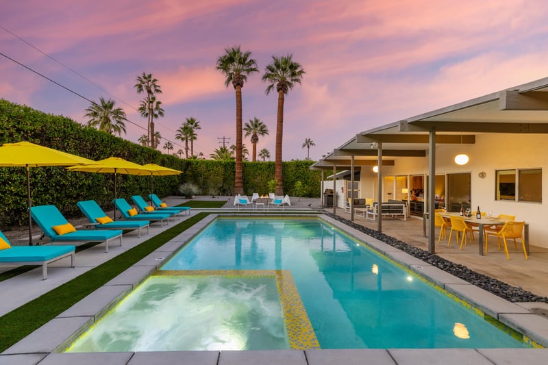 Modern pool and spa area with dramatic sunset sky, perfect for evening relaxation in this stylish Palm Springs setting.