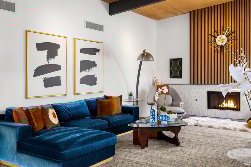 Sink into plush blue velvet seating while the fireplace crackles nearby, creating your perfect retreat for intimate conversations.