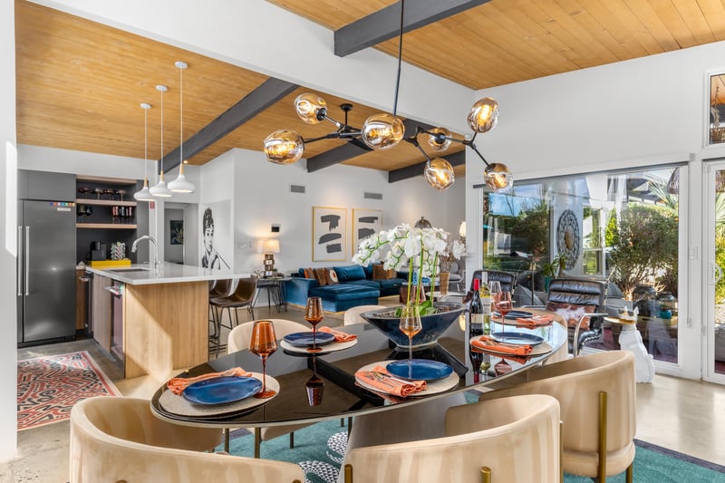 Stunning openconcept space where your dining flows into the living area, featuring warm wood ceilings and modern lighting that creates perfect ambiance.